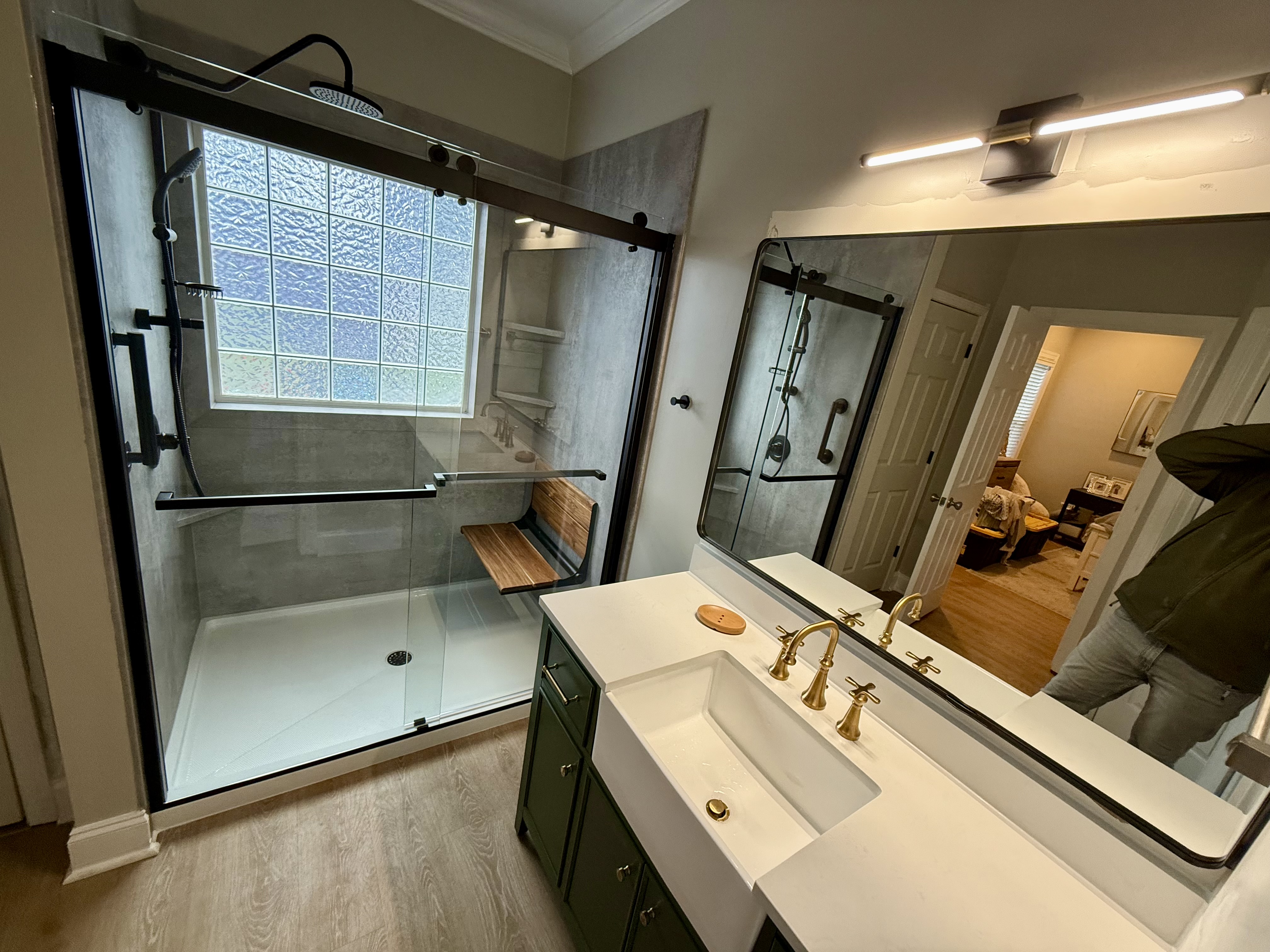 A bathroom with a walk in shower next to a sink